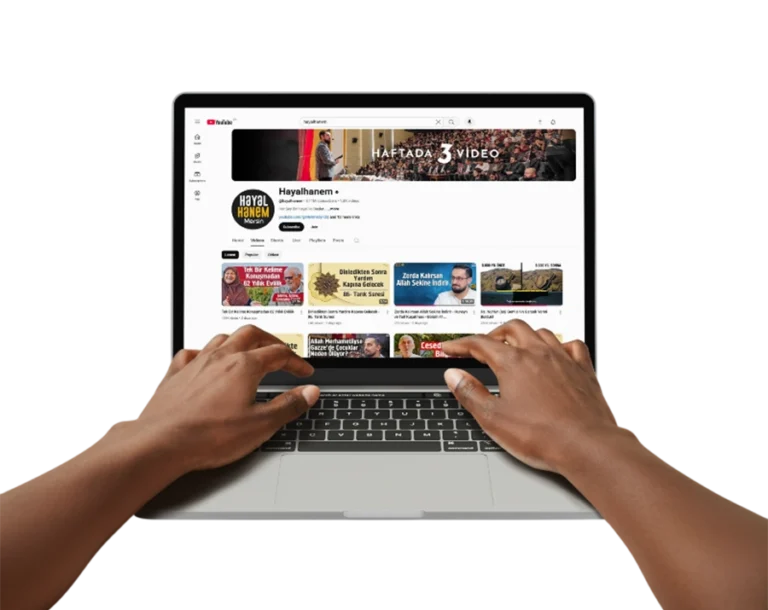 A transparent PNG of a laptop displaying the Hayalhanem YouTube channel homepage, with dark-skinned hands typing on the keyboard.